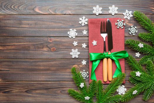 Top view of festive cutlery on new year wooden background. Christmas decorations with empty space for your design. Holiday dinner concept.