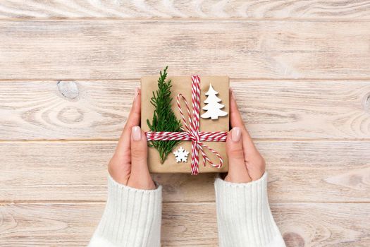 gift box wrapped in recycled paper, with ribbon bow, with ribbon on rustic background.