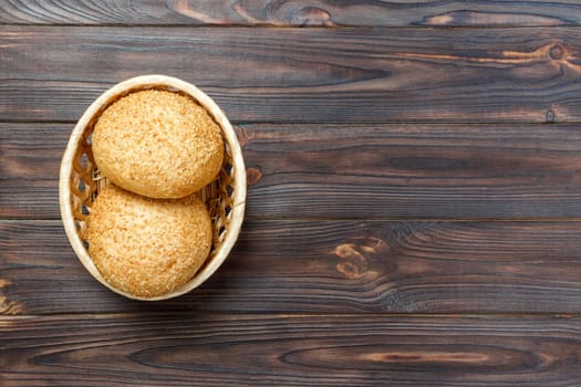 Homemade fresh buns in a basket on old wooden table.