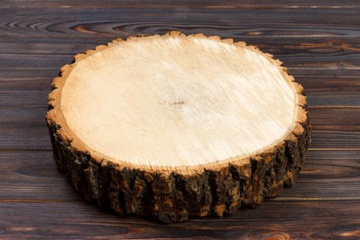 Tree stump round cut with annual rings on wooden background from top view