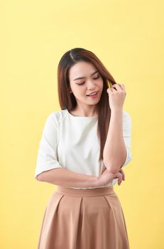 Beauty woman touch her long hair isolated on yellow background, asian beauty 