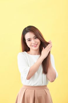 Beauty woman touch her long hair isolated on yellow background, asian beauty 