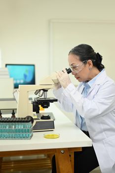 Professional scientists team conducting experiment in modern laboratory. Medicine and science researching concept.