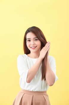 Beauty woman touch her long hair isolated on yellow background, asian beauty 