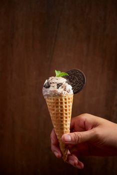 Sweet homemade ice cream with cookies in cone, selective focus