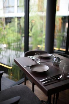 Table set with silverware dish and glass in restaurant