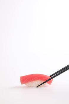 Tuna sushi with chopsticks , Japanese food isolated in white background