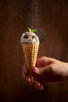 Sweet homemade ice cream with cookies in cone, selective focus