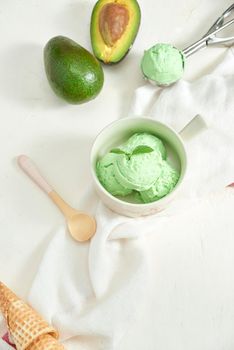 homemade organic avocado ice cream, with ice cream cones. On a grey stone table, copy space