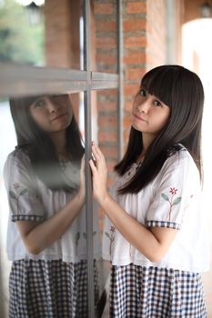 portrait of asian girl with white shirt and skirt looking in outdoor urban background