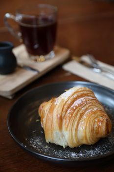 croissant with coffee close up on wood background