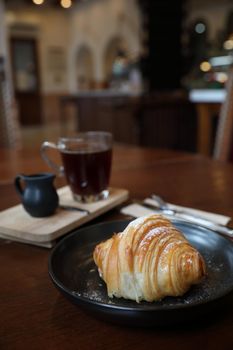 croissant with coffee close up on wood background