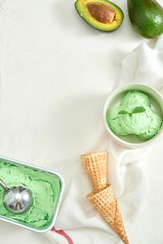 homemade organic avocado ice cream, with ice cream cones. On a grey stone table, copy space