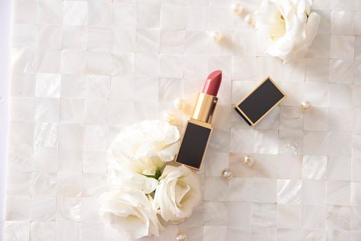 Lipstick with beautiful flowers on white background