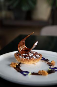 Chocolate dessert cake with berry sauce and almond with decorated