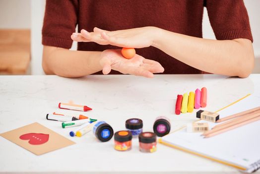 Female hands working with polymer clay. The process of working with the plastic on a white background.