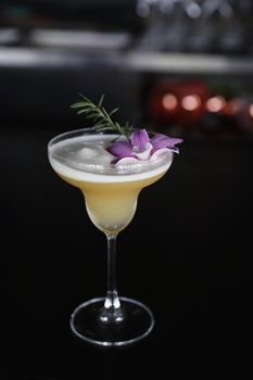 Yellow Cocktail glass with ice at a bar counter