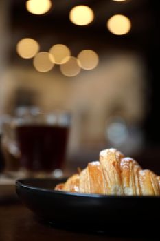 croissant with coffee close up on wood background