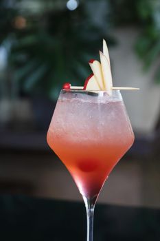 Pink Cocktail glass with ice at a bar counter