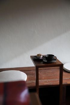 Coffee cup with muffin on wood table in local coffee shop