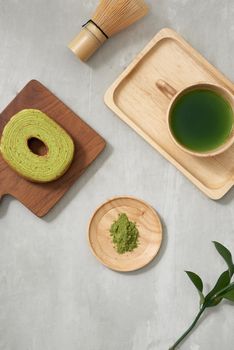 Green tea matcha in a wooden cup with German cake on the brown mat close-up