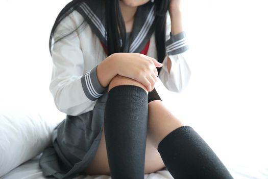 Portrait japanese school girl sitting in white tone bedroom