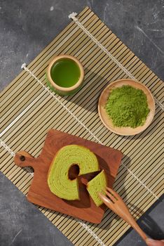 Matcha green tea latte in a cup and tea ceremony utensils with German cake. Copy space