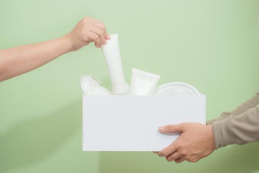 Man's hands holding a carton with plastic garbage for recycling. Recycle concept