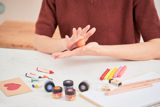 Female hands working with polymer clay. The process of working with the plastic on a white background.