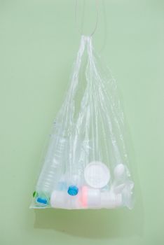 Plastic bag filled with household waste isolated on white background.