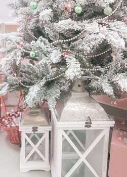 Beautiful composition with vintage Christmas lantern under the Christmas tree with silver branches, vertical.