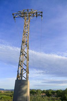 Power lines tower under blue sky in the countryside in Spain