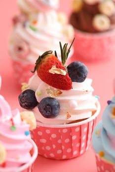 Colorful cupcakes isolated in pink background