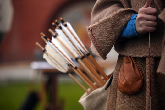 Wooden arrows for the bow. Hand crafted arrows in medieval style. Arrows with feather plumage in archer's quiver. Historical reconstruction - arrows for the bow. Medieval set of archer.