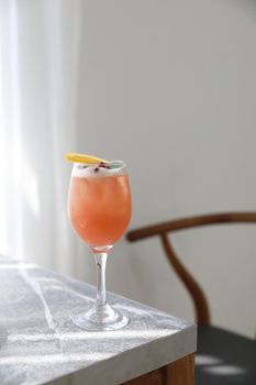 Pink Cocktail glass with ice at gray table