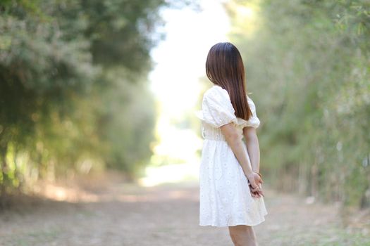 Beautiful young woman with white dress on bamboo forest background