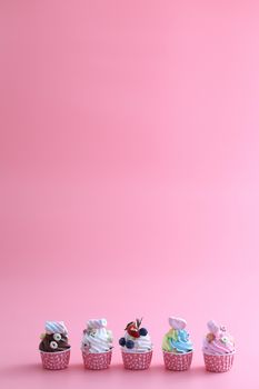 Colorful cupcakes isolated in pink background