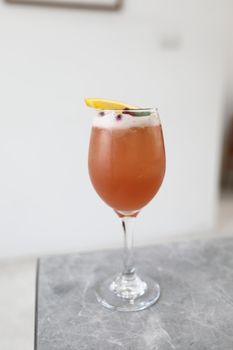 Pink Cocktail glass with ice at gray table