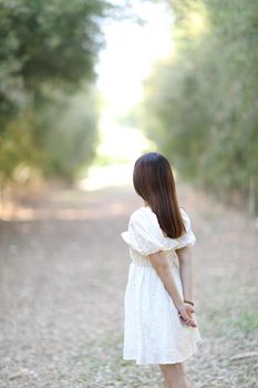 Beautiful young woman with white dress on bamboo forest background