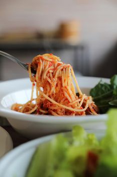 spaghetti Bolognese with italian sausage and tomato sauce with parmesan cheese and basil 