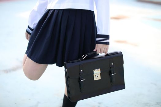 A hand of school girl with school bag in stadium background