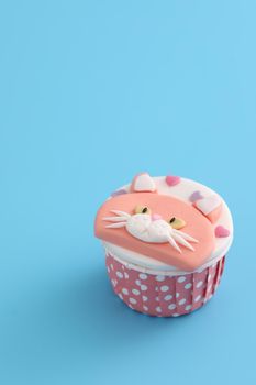 Cute cat cupcake isolated in blue background