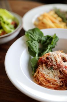 spaghetti Bolognese with italian sausage and tomato sauce with parmesan cheese and basil 