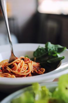 spaghetti Bolognese with italian sausage and tomato sauce with parmesan cheese and basil 