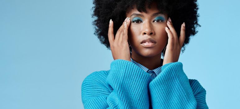 Blue makeup, fashion and beauty with a black woman in studio against a wall background with mockup. Cosmetics, face and eye shadow with a young female posing for contemporary or edgy style.