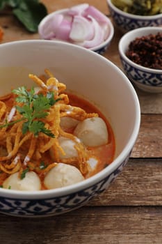 Local northern Thai food Egg noodle curry with meatballs on wood background