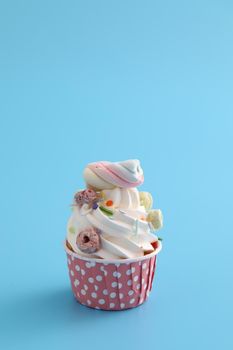 Colorful cupcake isolated in blue background