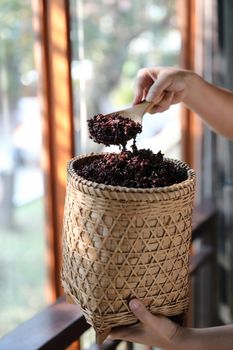 Boiled riceberry rice on Wicker basket with spoon in close up