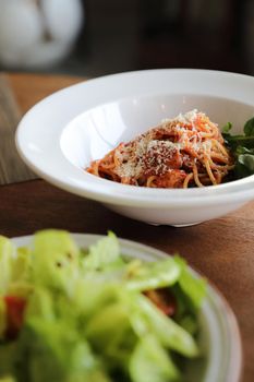 spaghetti Bolognese with italian sausage and tomato sauce with parmesan cheese and basil 