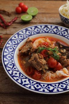 Local northern thai food Rice noodles with pork in spicy soup in wood background